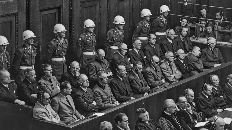 Nazi defendants sit in rows with soldiers Nuremberg trials