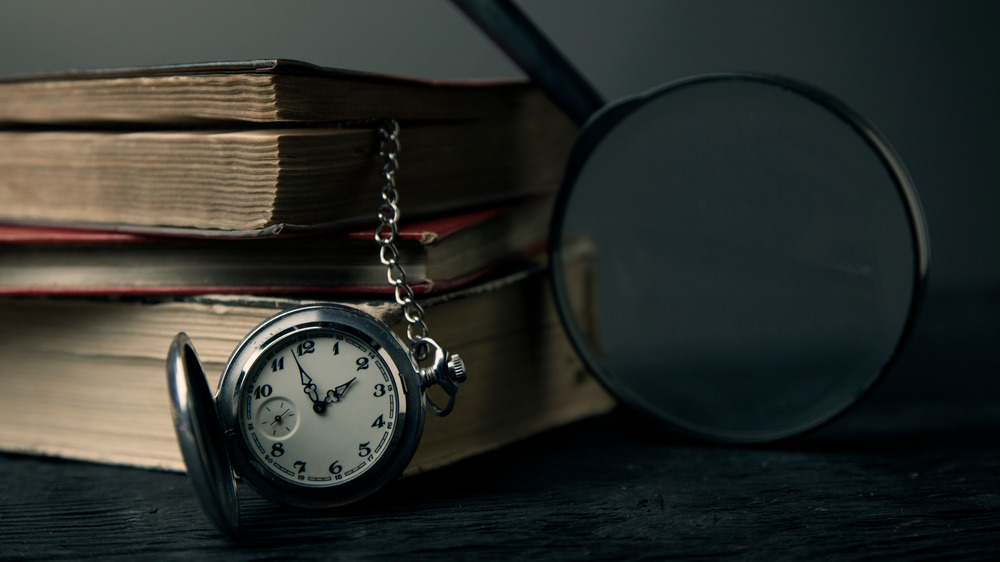 old-timey pocketwatch and magnifying glass