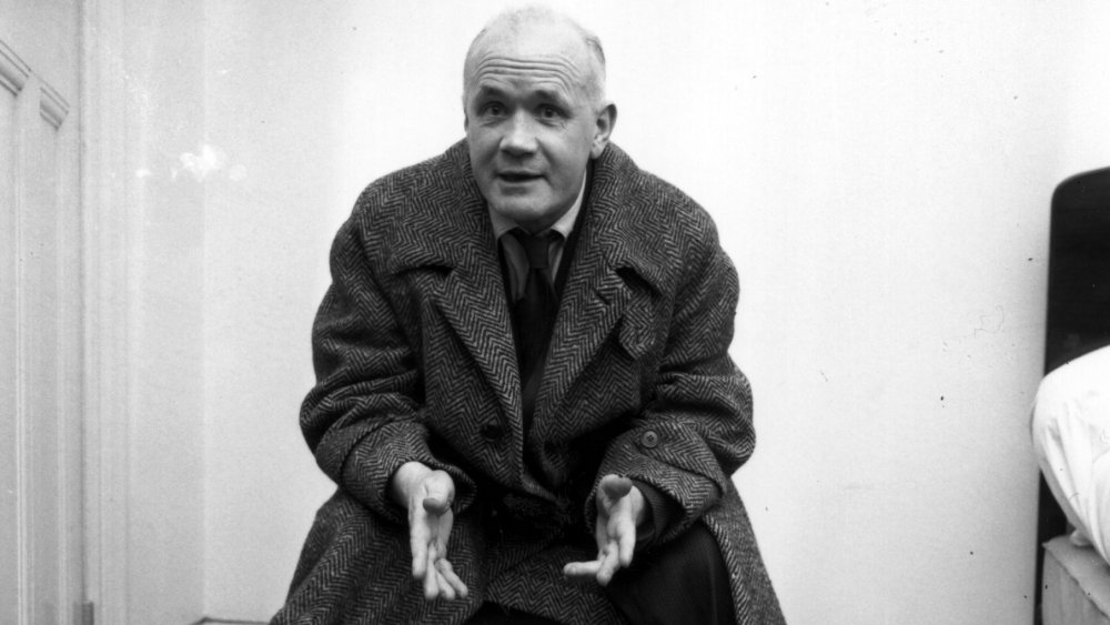 Jean Genet, French novelist and playwright, sitting on a chair.