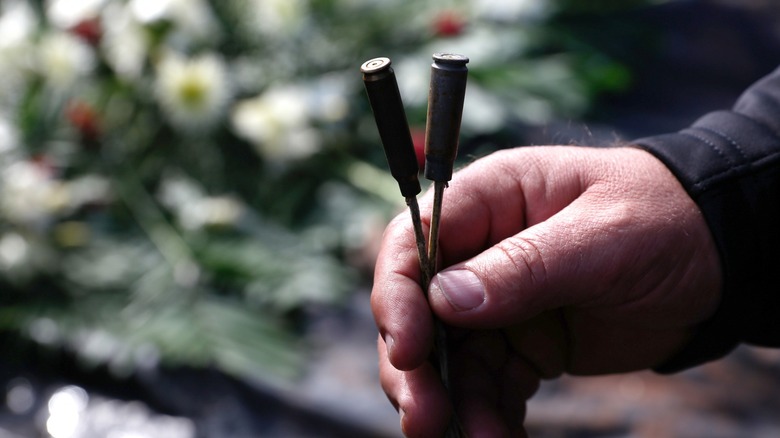 Man holding expended bullet cases