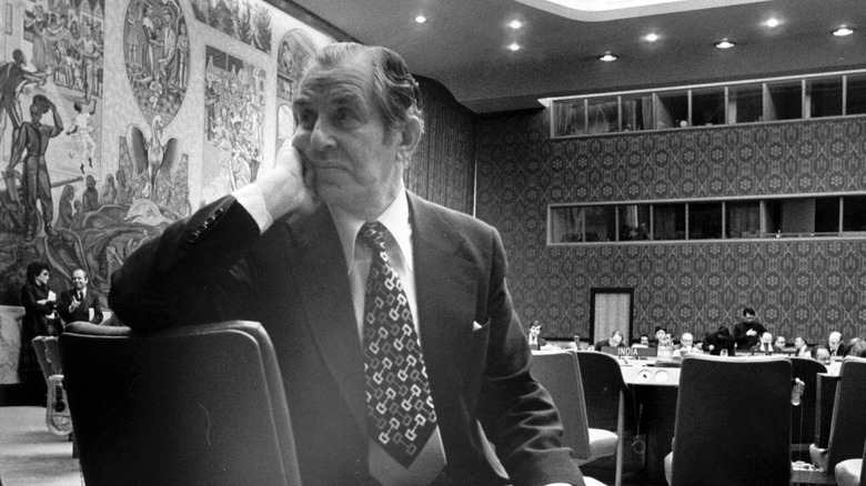 Chaim Herzog sitting with his head in his hand wearing a suit and tie, picture in black and white