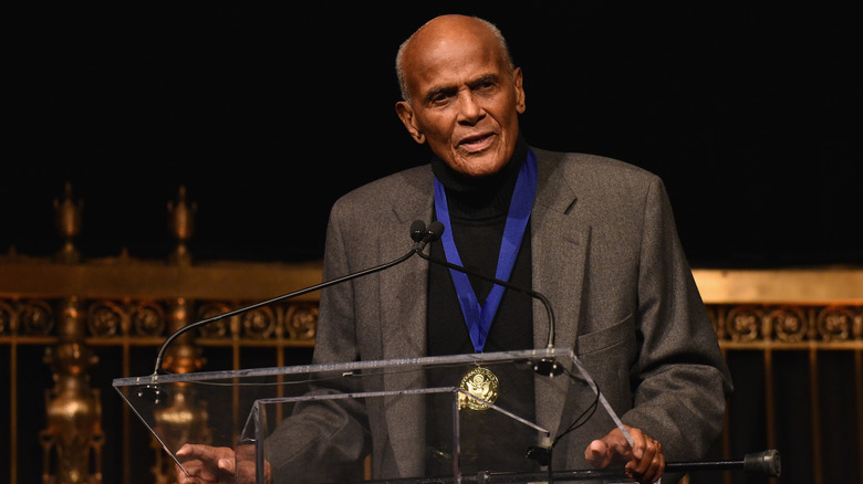 Harry Belafonte speaking at a podium