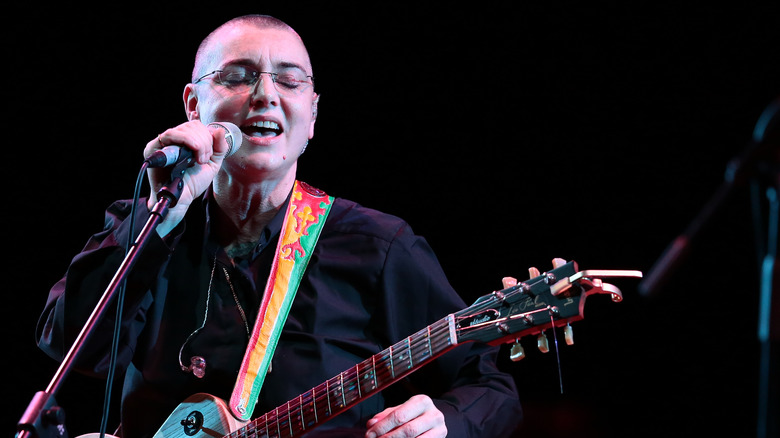 Sinead O'Connor playing guitar glasses