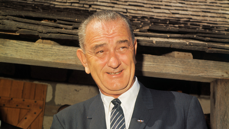 Lyndon B Johnson suit wood cabin smiling