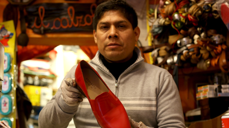 Pope's shoemaker posing with shoes