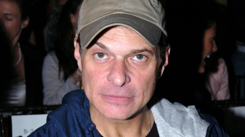 david lee roth sneering into camera wearing baseball cap