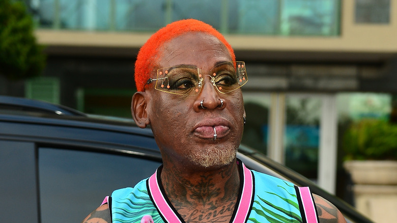 Dennis Rodman glasses orange hair outside by car