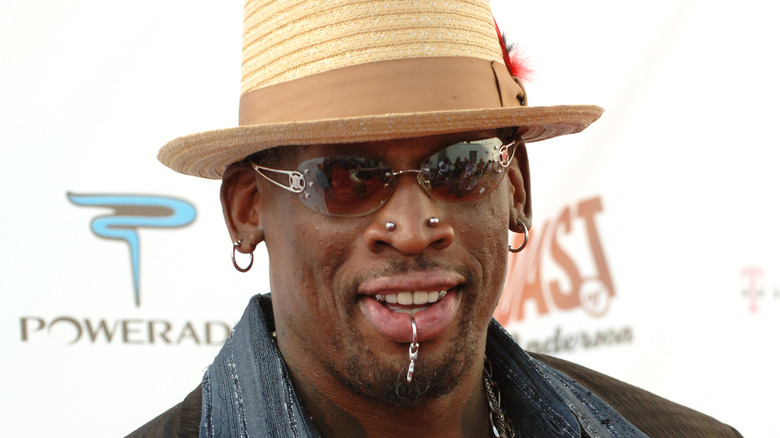 Dennis Rodman smiling hat sunglasses at event