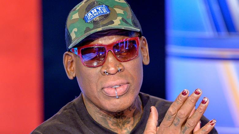 Dennis Rodman camo hat red sunglasses at event