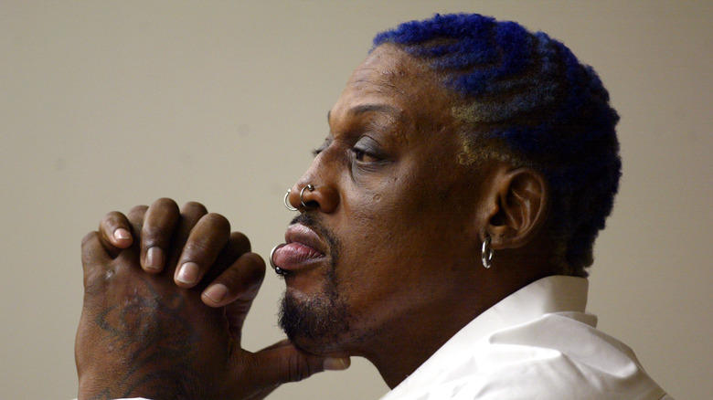 Dennis Rodman white shirt purple hair hands clasped