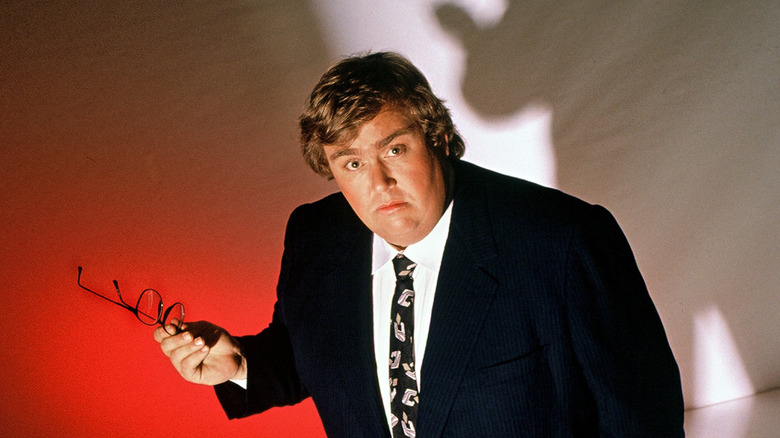 john candy in suit staring up at camera