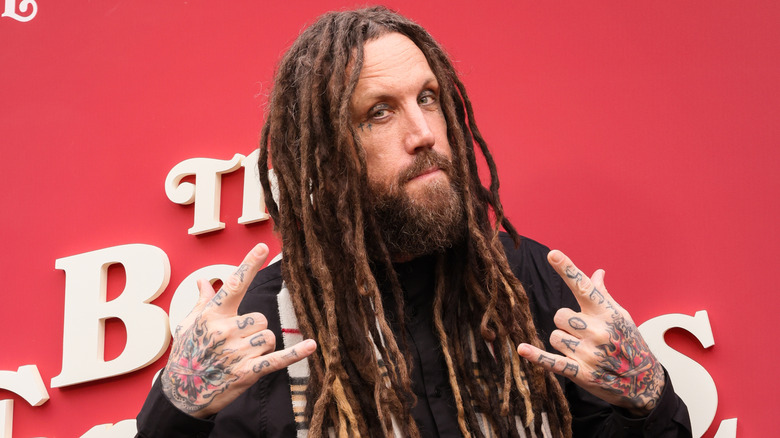 Brian 'Head' Welch holding up the devil horns on the red carpet in 2024