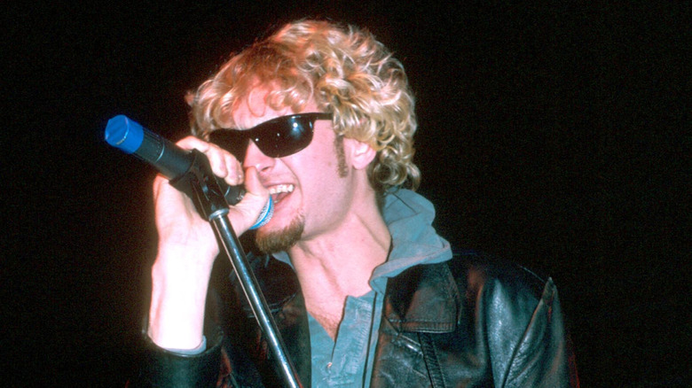 Layne Staley in sunglasses holding mic stand while singing