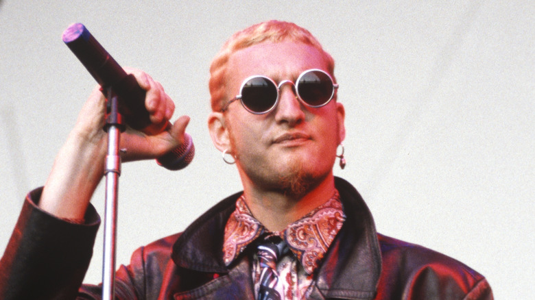 Layne Staley smirking with round sunglasses onstage