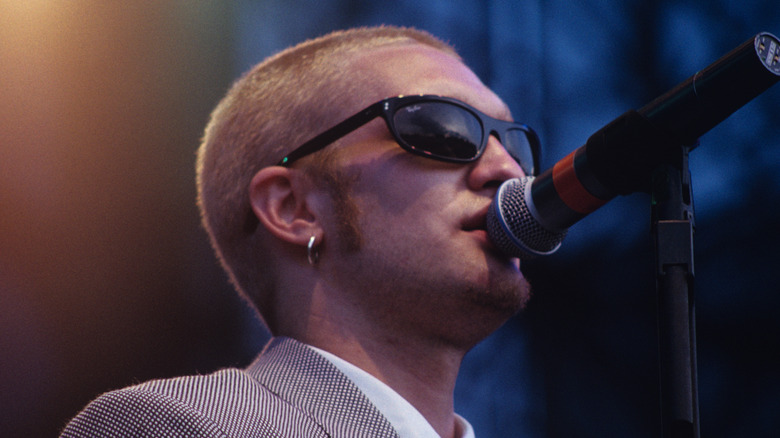 Layne Staley in profile in suit singing into microphone