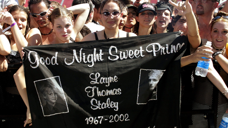 fans hold up layne staley memorial banner at concert