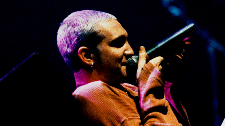 Layne Staley singing while reclining in orange sweater