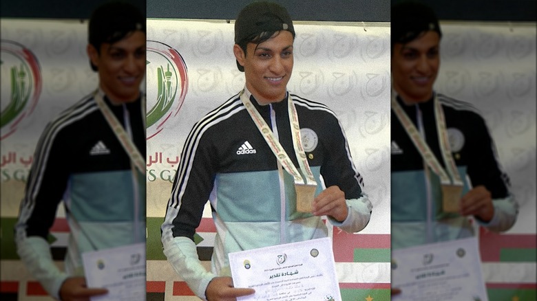 Imane Khelif smiling holding up medal certificate