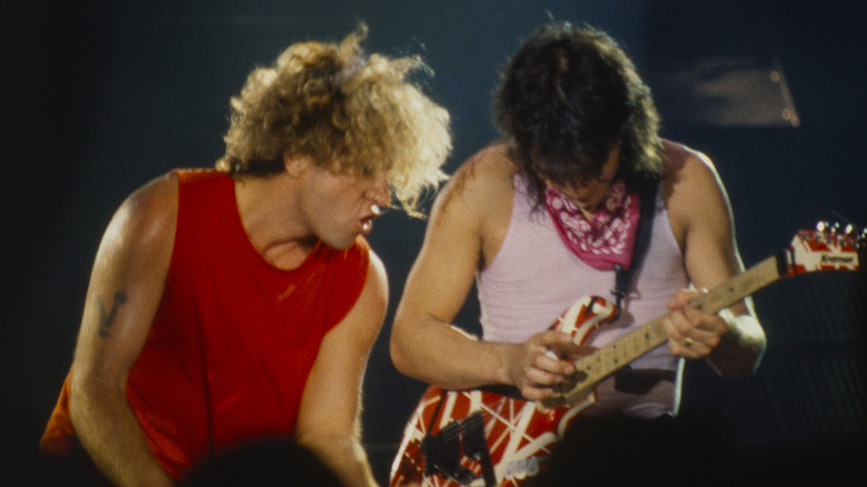 sammy hagar looks on while eddie van halen plays on stage in the 1980s