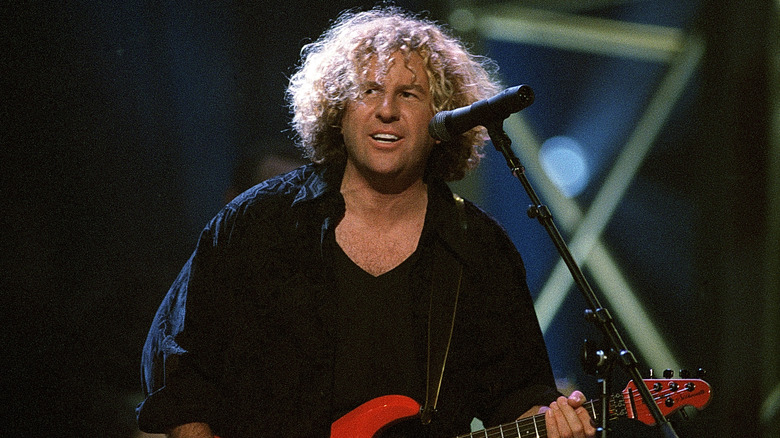 sammy hagar onstage behind a microphone in the mid 1990s