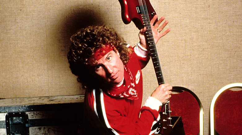 sammy hagar in all red holding red guitar in 80s publicity photo