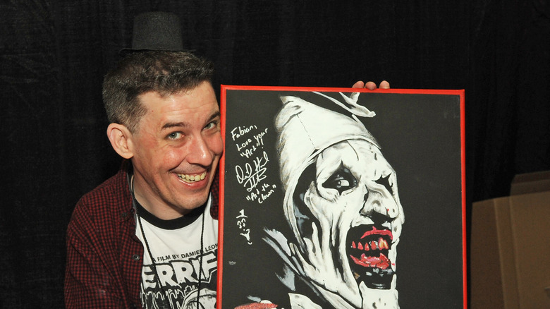 David Howard Thornton posing with Art the Clown poster