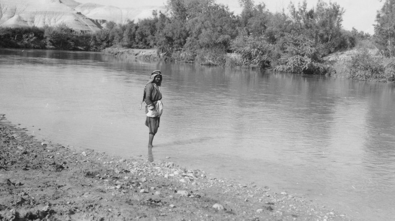 man standing in the jordan river