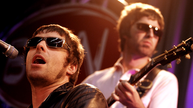 Noel and Liam Gallagher playing onstage