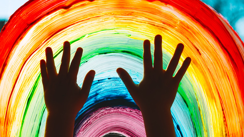 child's hands on rainbow