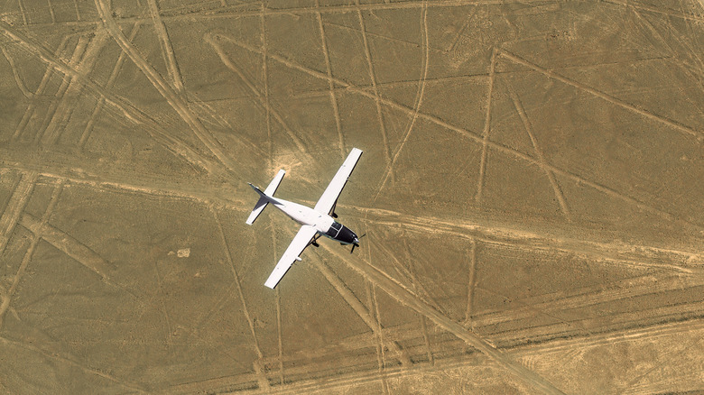 An airplane flies over Nazca lines