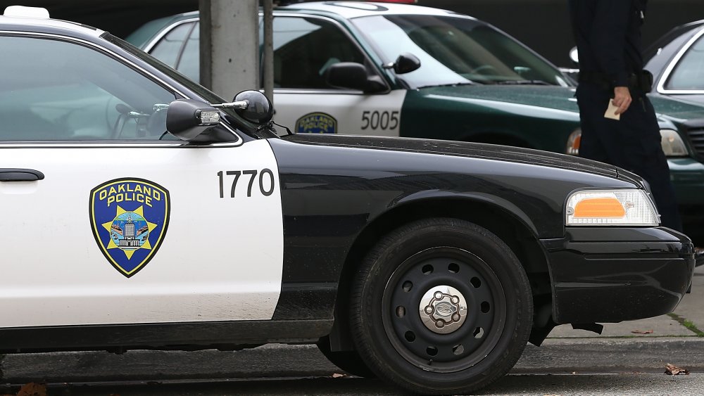 An Oakland Police officer walks by patrol cars at the Oakland Police headquarters on December 6, 2012 