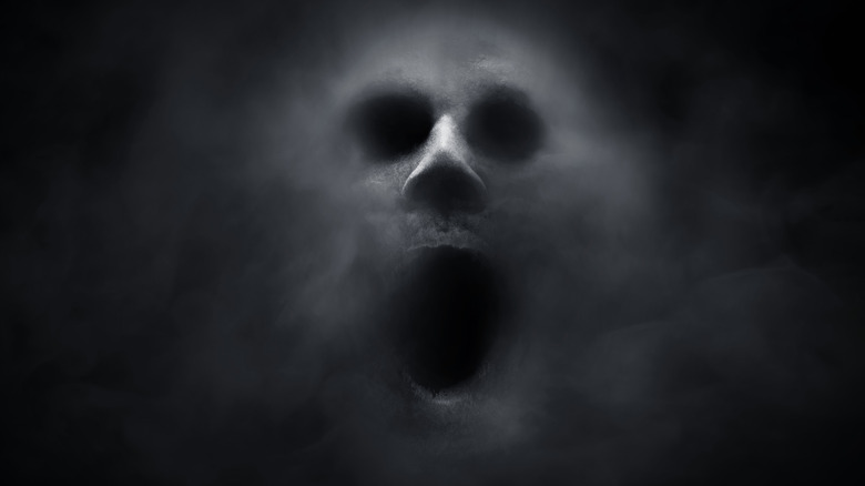 screaming face on a black background darkness