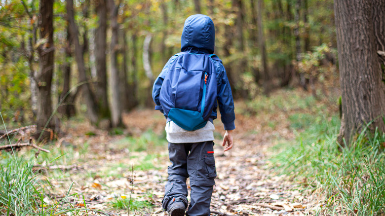 Boy running through forest