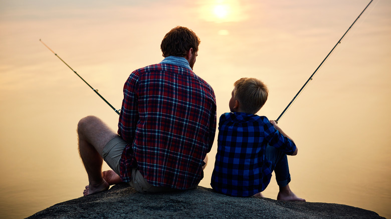 A father and son fishing at sunset