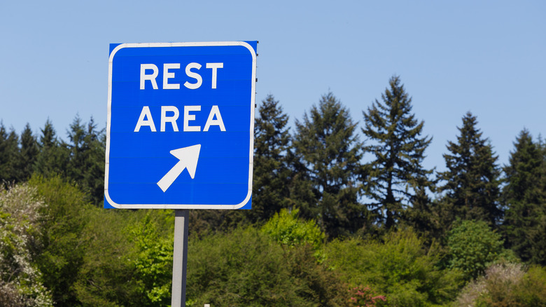 Blue Rest Area sign with trees in the background