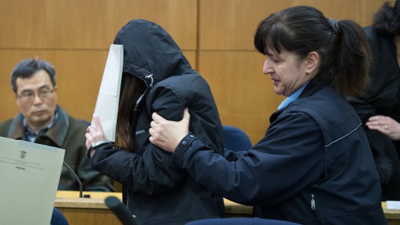 person on trial covering face