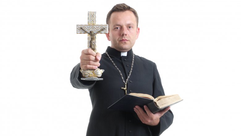 roman catholic priest holding cross