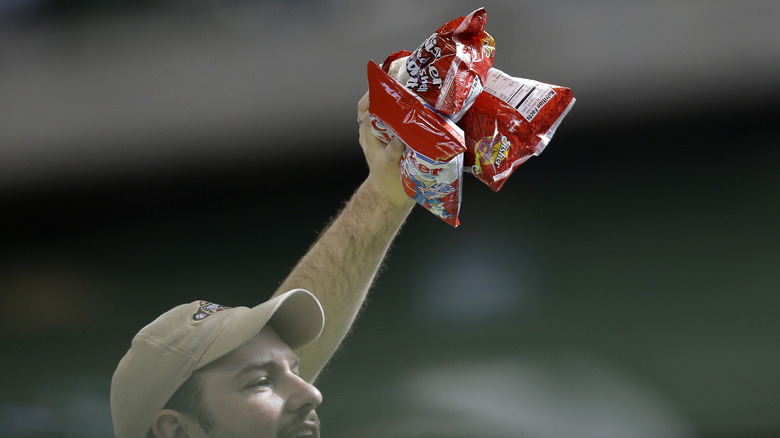 Peanut vendor holding peanut bags