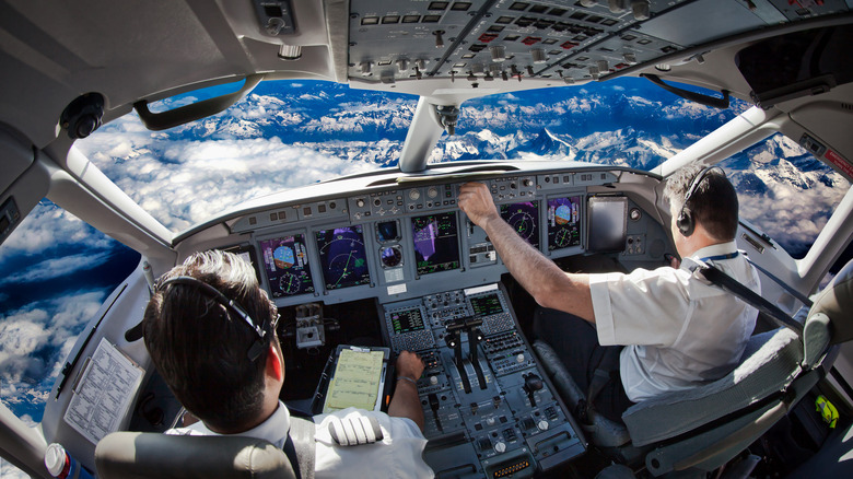 Pilots in cockpit piloting plane