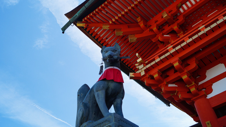 fox statue in front of inari shrine