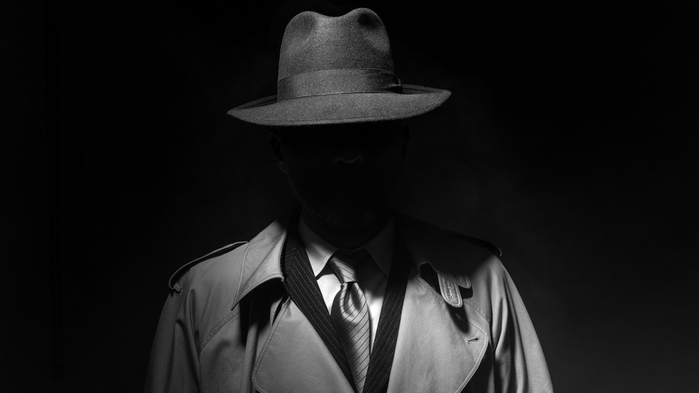 dark man in trench coat and fedora