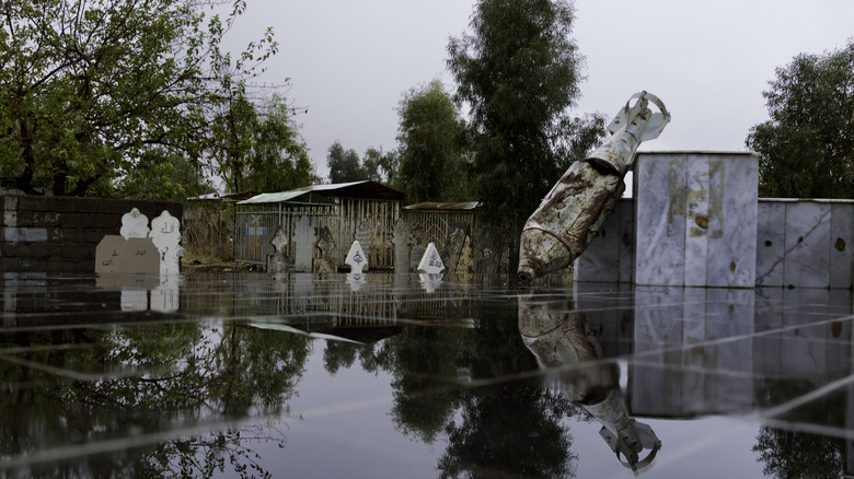 Monument commemorating the Halabja massacre using a dented used rocket/chemical attack missile. the ground is reflective and shows a reflection of the rocket