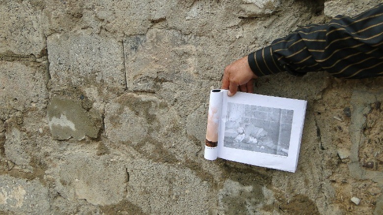 Contemporary Photo of Bodies of Omer Khawmar and Child By the Wall Where Their Bodies Were Found