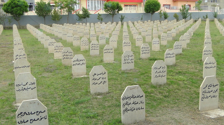 Graveyard full of identical tombstones with different names in a traingular pattern depicting the names of Kurdish people who died in the Halabja massacre