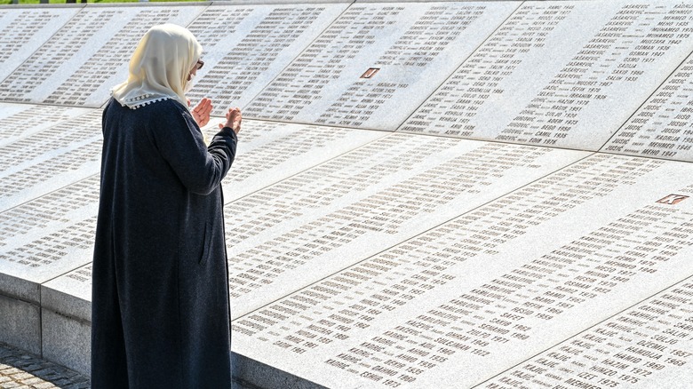 Bosnian woman praying in graveyard in Memorial centre Srebrenica. 