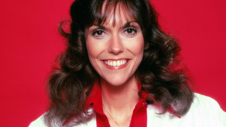 Karen Carpenter smiling red background