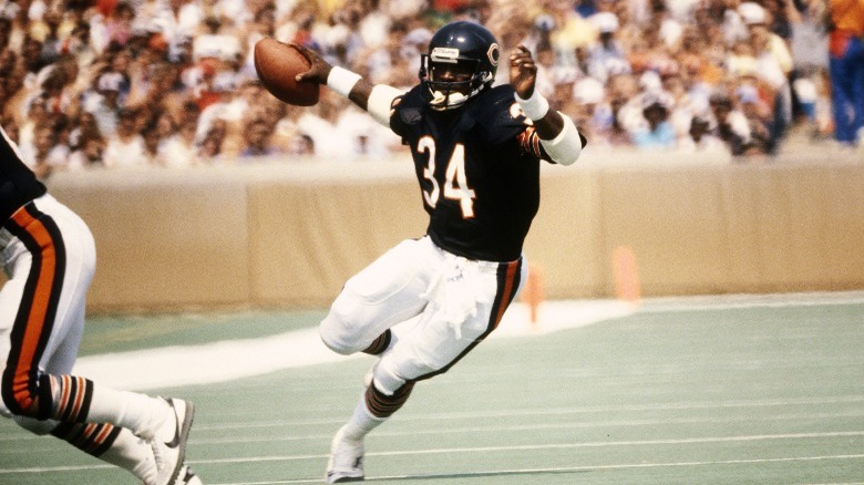 Walter Payton holding football, running