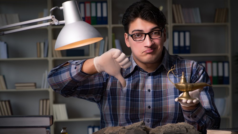 Man giving a "thumbs down" while holding genie lamp