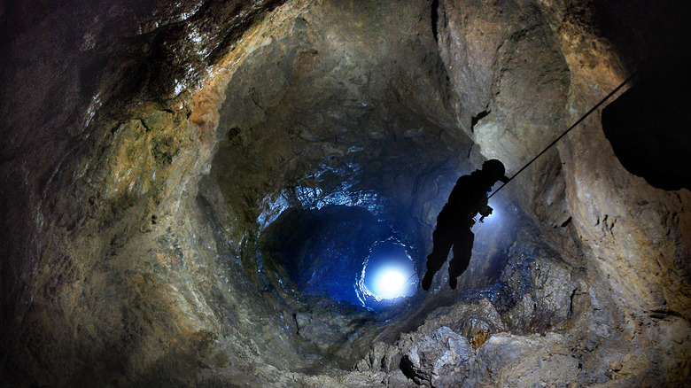 Caver descending into cave