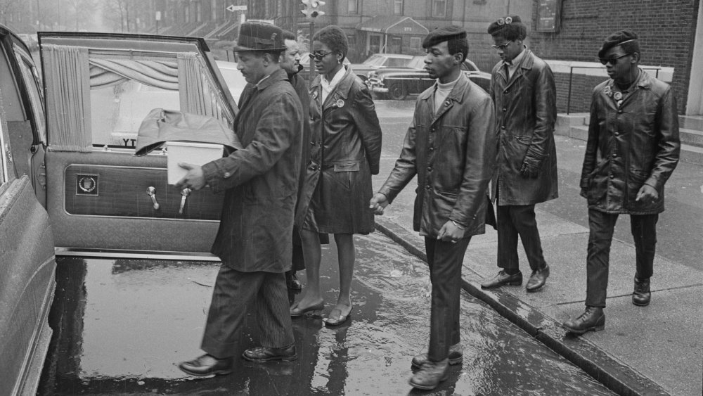 Members of the Black Panther Party attend the funeral of a baby of one of the Black Panthers and a Swedish mother, USA, 19th April 1969. The small coffin is carried into the hearse.